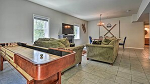 A living room with a foosball table, two green sofas, a TV, and a fireplace. - Golf & Hike! Condo at Whitetail Resort (Mercersburg)