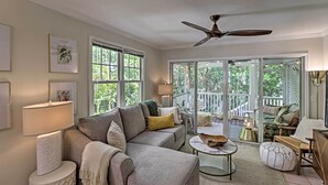 A spacious living room with a grey sofa, a coffee table, and a ceiling fan. - Charming 'Boho Breeze' Retreat w/ Pool Access (Key West)
