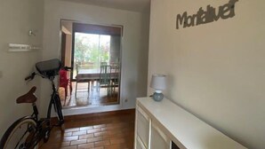 Une pièce avec un vélo, une table, des chaises et une lampe.