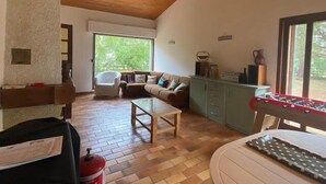 Un salon spacieux avec un plafond en bois, un canapé, une table basse et une table de baby-foot.