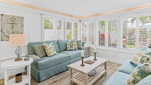 A living room with a blue sofa, a wooden coffee table, and a white side table.