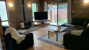 Ein Wohnzimmer mit Kamin, Fernseher und einer Couch.