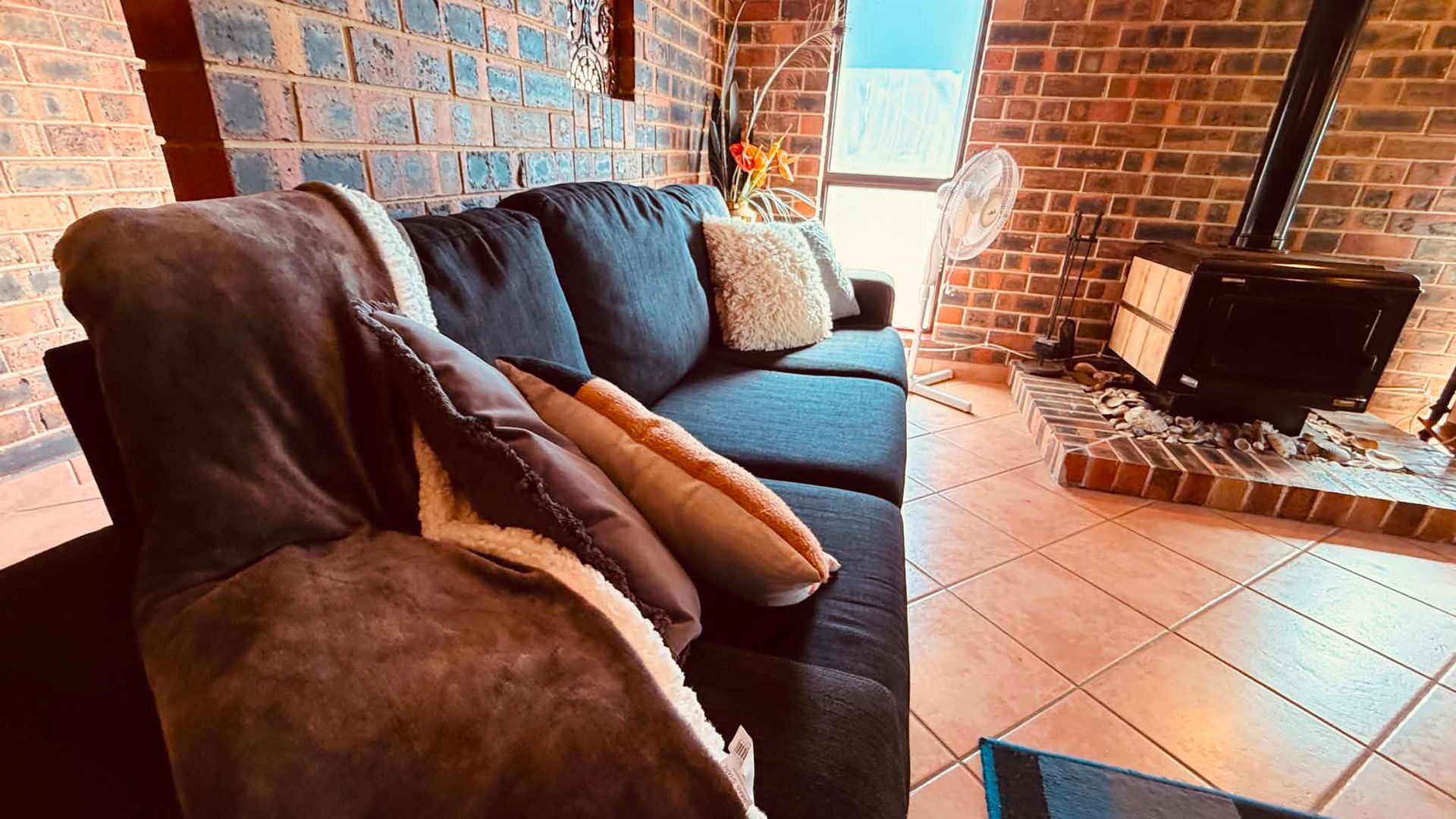 A living room with a sofa, a fireplace, and a television.