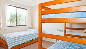A bunk bed with a lower bed and a wardrobe.