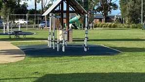 Un parc infantil amb una estructura per escalar i un tobogan.