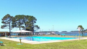 A swimming pool with a covered area, benches, and a no swimming sign.