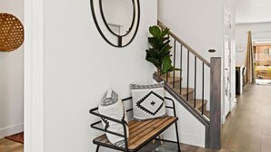 A staircase with a wooden handrail and black metal balusters, leading to an upper floor. - St. George Getaway, Brand New 5 BD Luxury Townhome (St. George)