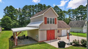 A two-story house with a garage, a covered patio, and a lawn. - 70" TV, pool table, darts, 10 minutes from Wildlife Boat Ramp + Board & Batten (Lexington)