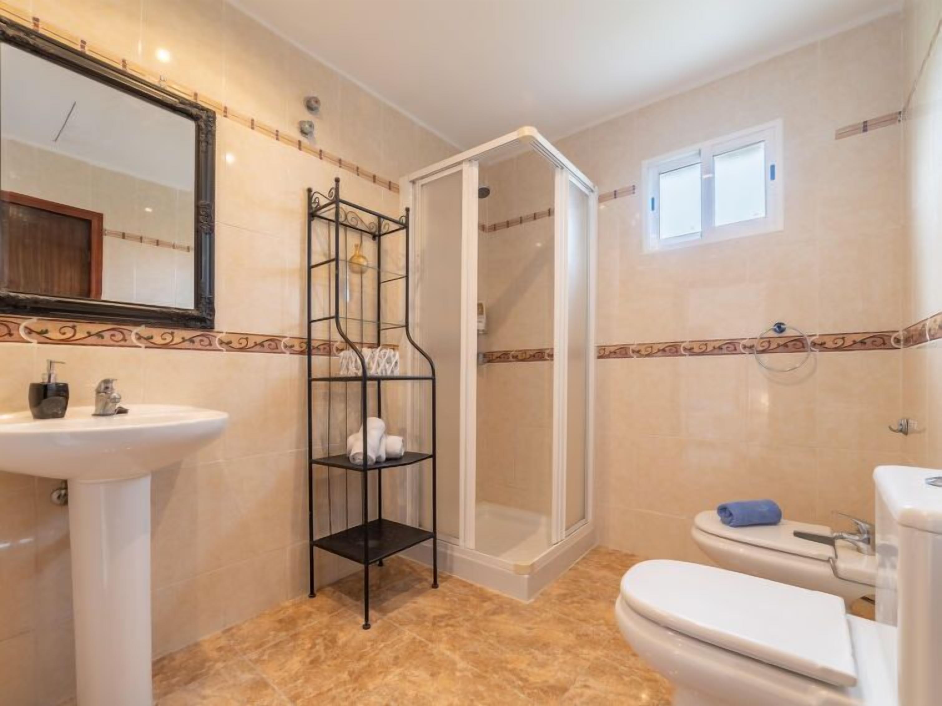 A bathroom with a sink, toilet, and shower.