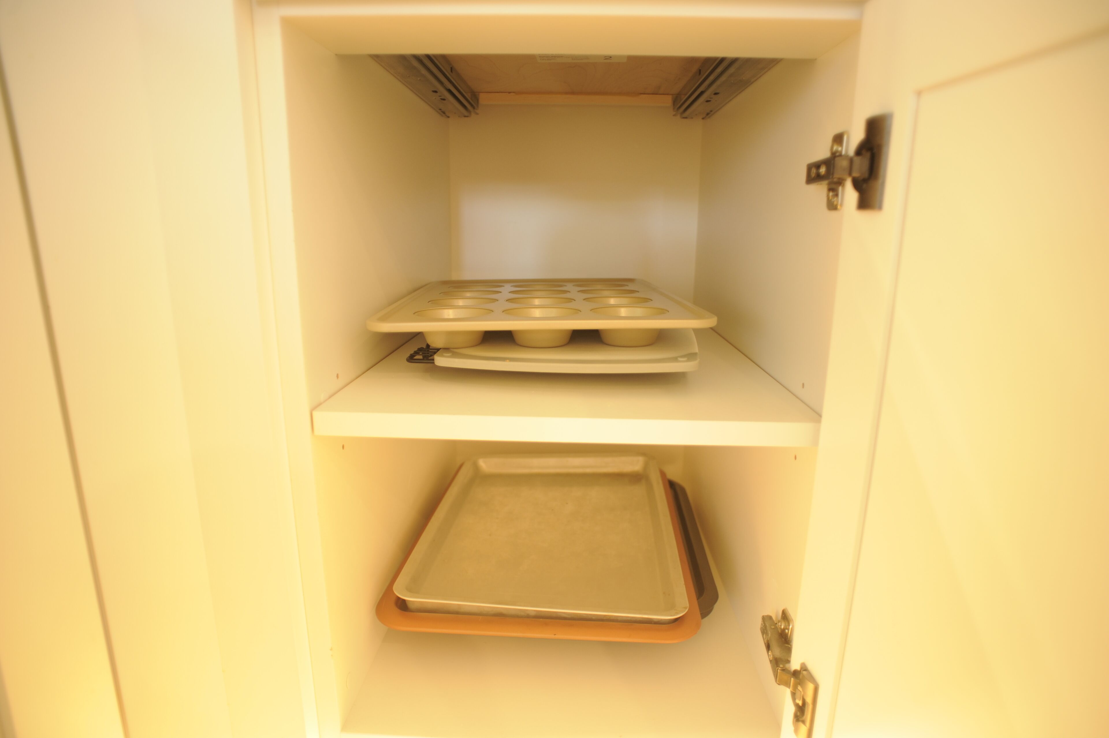 Una cocina con horno empotrado, una bandeja para muffins y una bandeja para hornear.