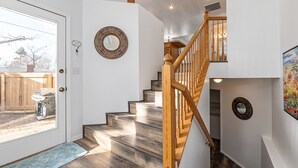 A staircase with wooden railings and a view of a backyard through a glass door. - Cozy House Near Boise State University, Downtown and Boise River Greenbelt. (Boise)