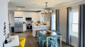 A modern kitchen with white cabinets, stainless steel appliances, and a central island.