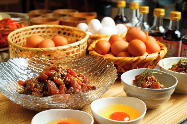 A table with various food items, including baskets of eggs and bowls of food.