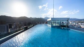 A rooftop infinity pool with a glass enclosure, offering a cityscape view.