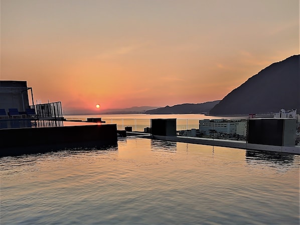 Una piscina al aire libre, tumbonas
