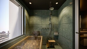 Ett modernt spa-rum med ett bubbelbad, en dusch och utsikt över staden.