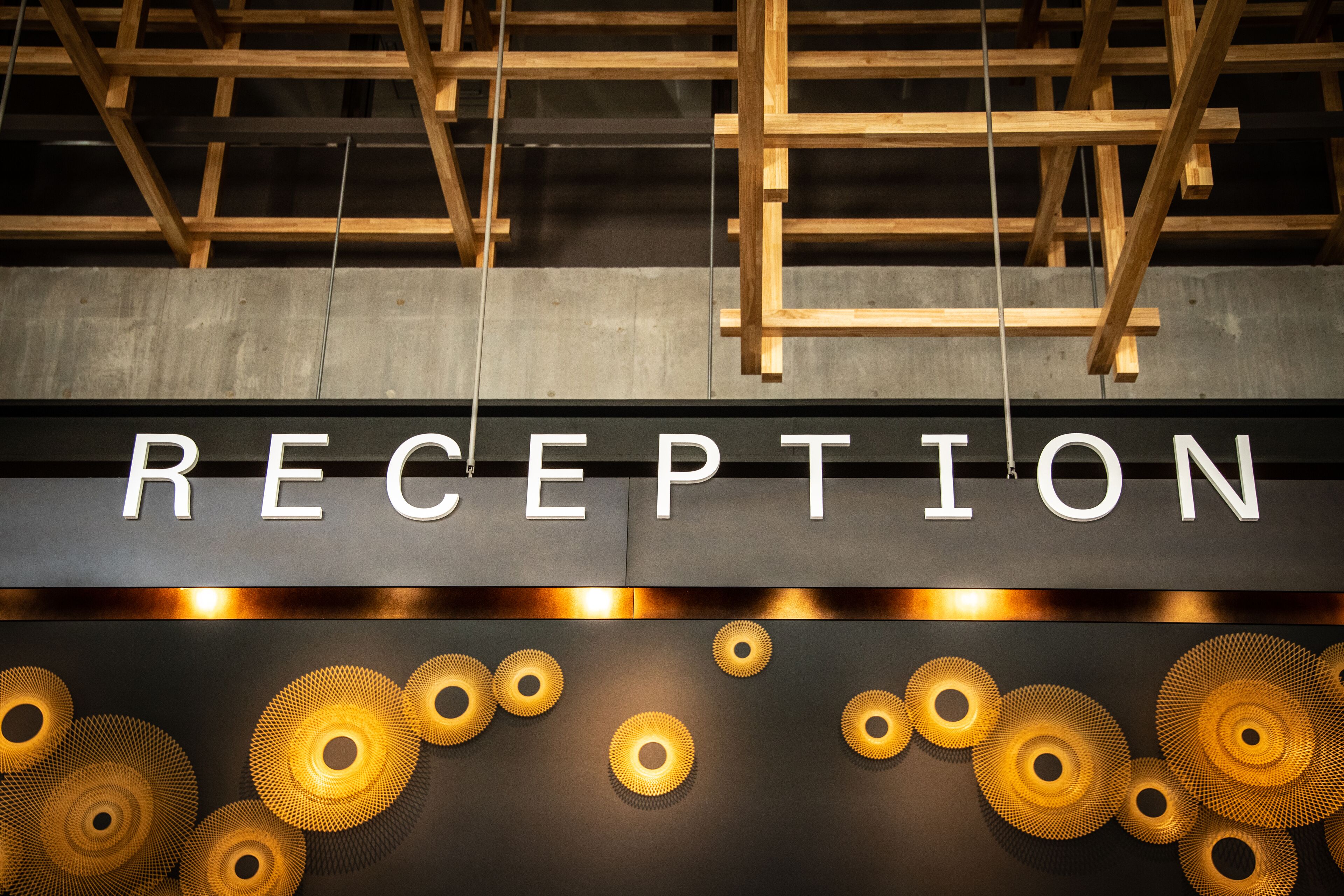 A reception area with a sign reading "RECEPTION" and decorative circular patterns on the wall.
