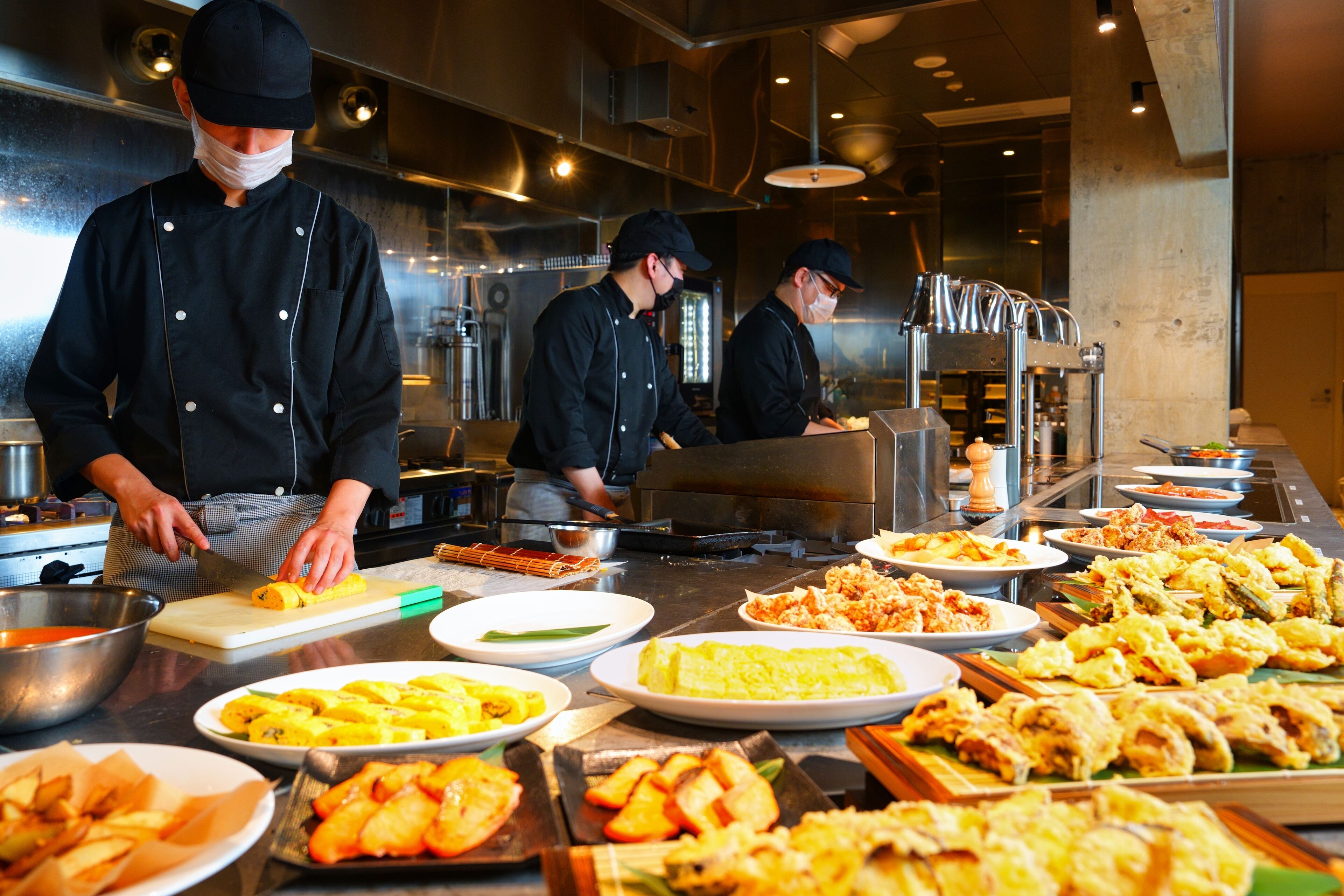 Un buffet con diversi chef che preparano cibo.