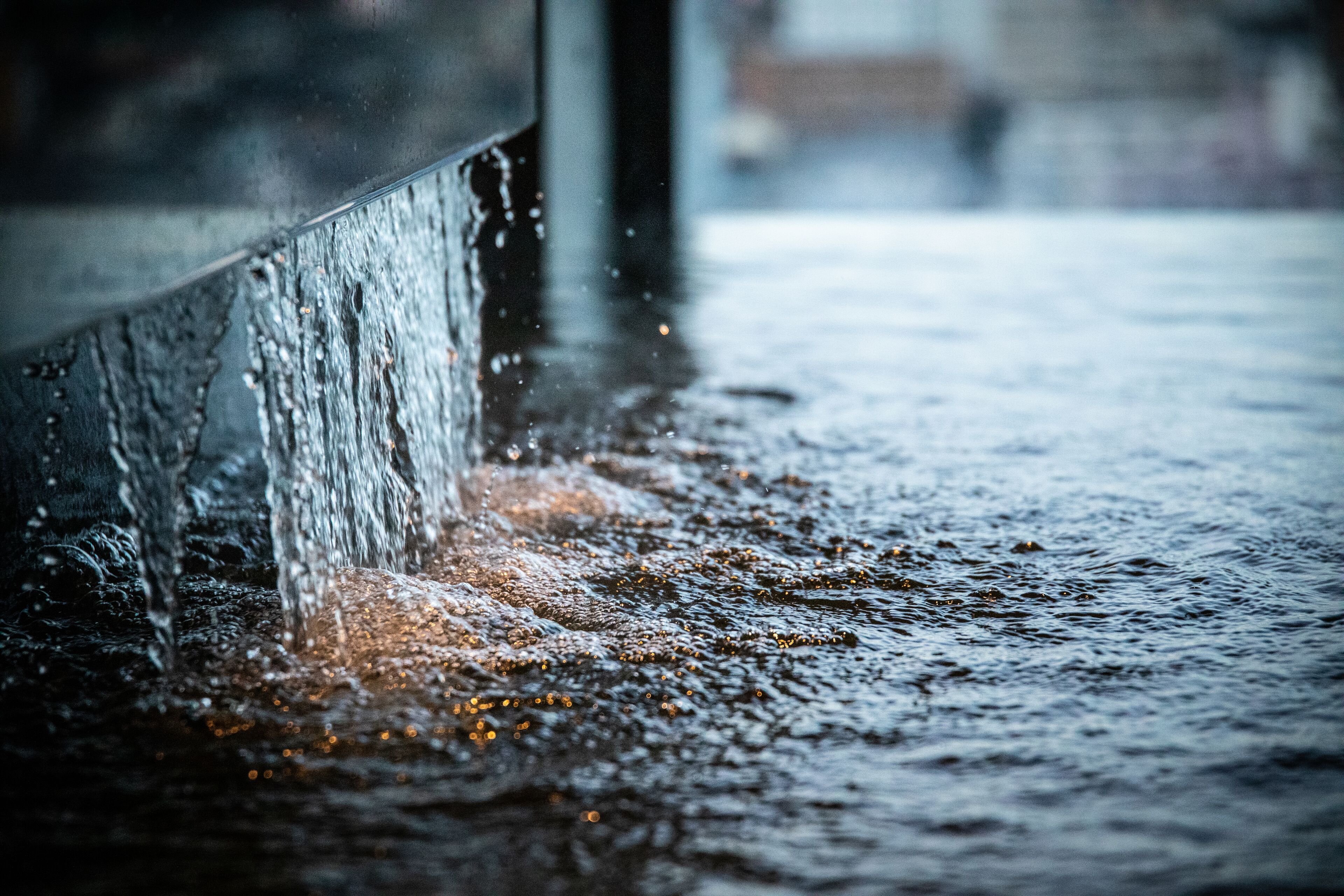 A close-up of water splashing against a metal surface.