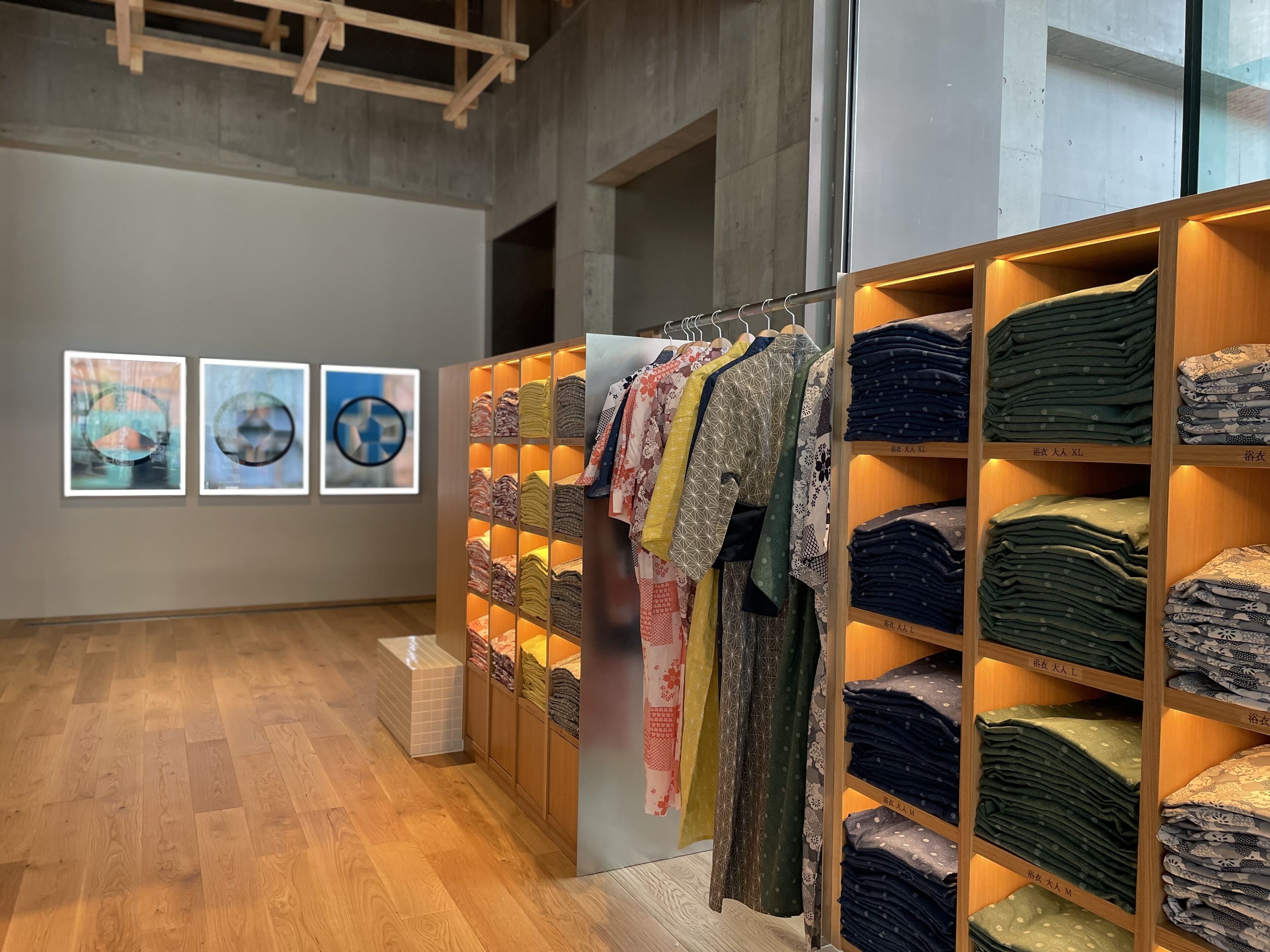 An art gallery with wooden floors and walls adorned with framed artworks.