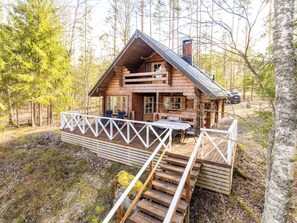 A cabin with a deck, a dining area, and a staircase leading to the entrance. - Paapuuri by Interhome (Asikkala)