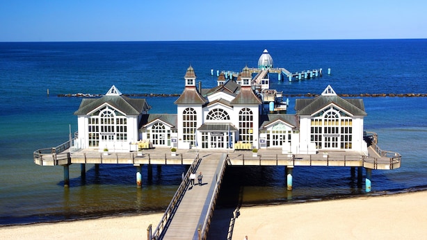 Hotel aan het water met meerdere gebouwen, een steiger en uitzicht op het strand.