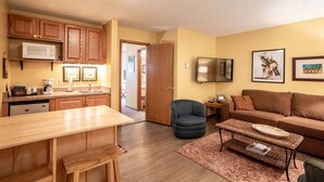 A compact living space with a kitchenette, a dining area, a sofa, and a TV. - Cozy condo w/great location by Flathead Lake - Cozy Marina Cay Getaway (Bigfork)