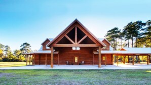 Una cabaña grande de madera con techo triangular y un porche cubierto.