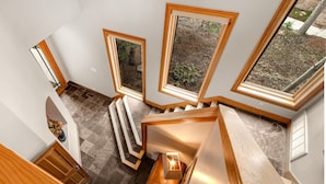 Ein modernes Interieur mit Treppe, großen Fenstern und einer hölzernen Bank.