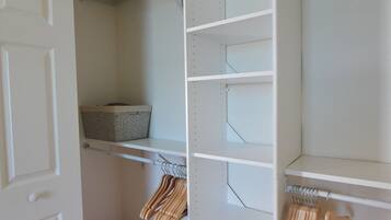 Features a spacious closet with shelving units and a hanging rod.
