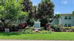 A sign with 'PALMS' written on it, surrounded by lush greenery and palm trees. - VACATION RENTAL!!! (North Fort Myers)