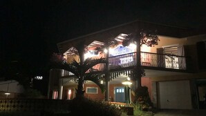 A two-story house with a balcony, a garage, and a well-lit entrance. - Villa Sol y Sombra the Cuban spirit (Schoelcher)