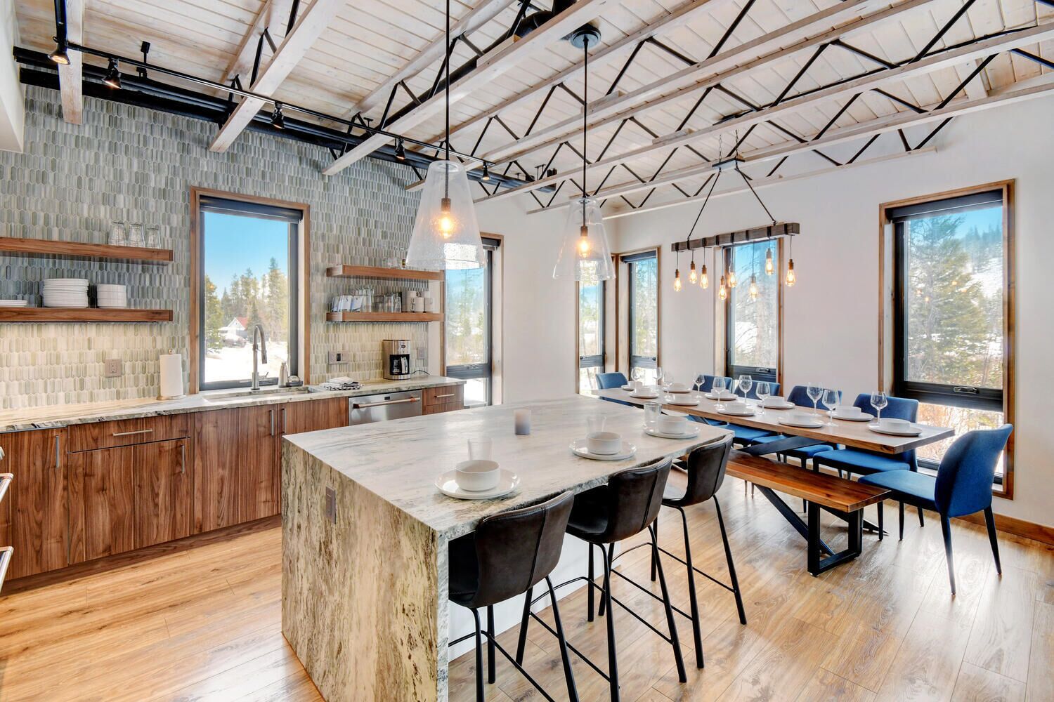 Una cucina moderna con un'isola grande, mobili in legno e una schiena di pietra.