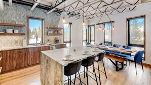 Una cocina moderna con una isla grande, armarios de madera y salpicadero de piedra.