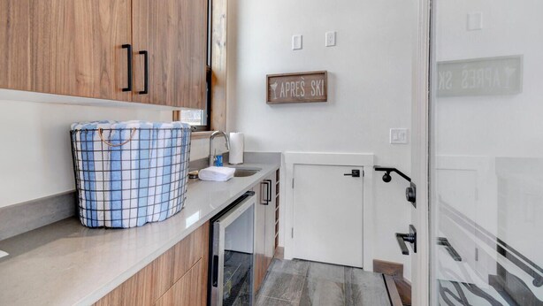 Una cocina moderna con armarios de madera, un lavabo y un perchero.