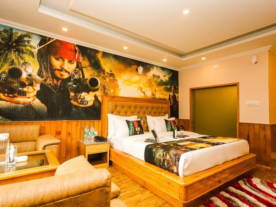 A spacious bedroom with a large bed, wooden headboard, and a mural of a pirate on the wall.