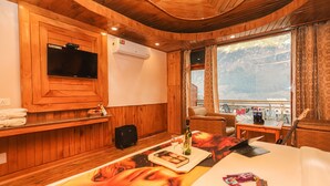 Une chambre d’hôtel à thème, décorée dans un style rustique, comprenant une télévision, la climatisation, un balcon avec vue, un bureau et une guitare.