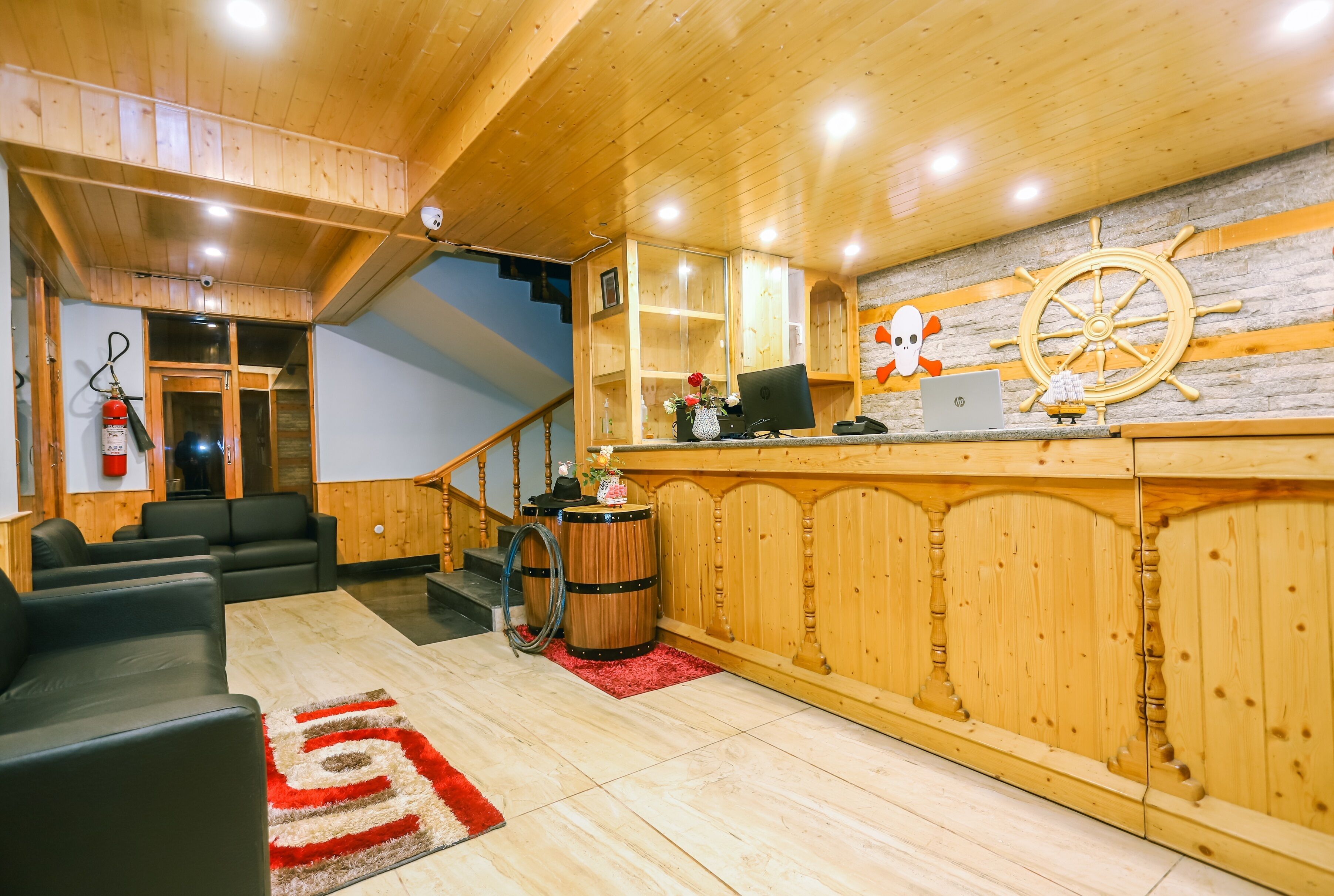Een houten interieur met een receptiebalie, computer en decoratieve objecten.