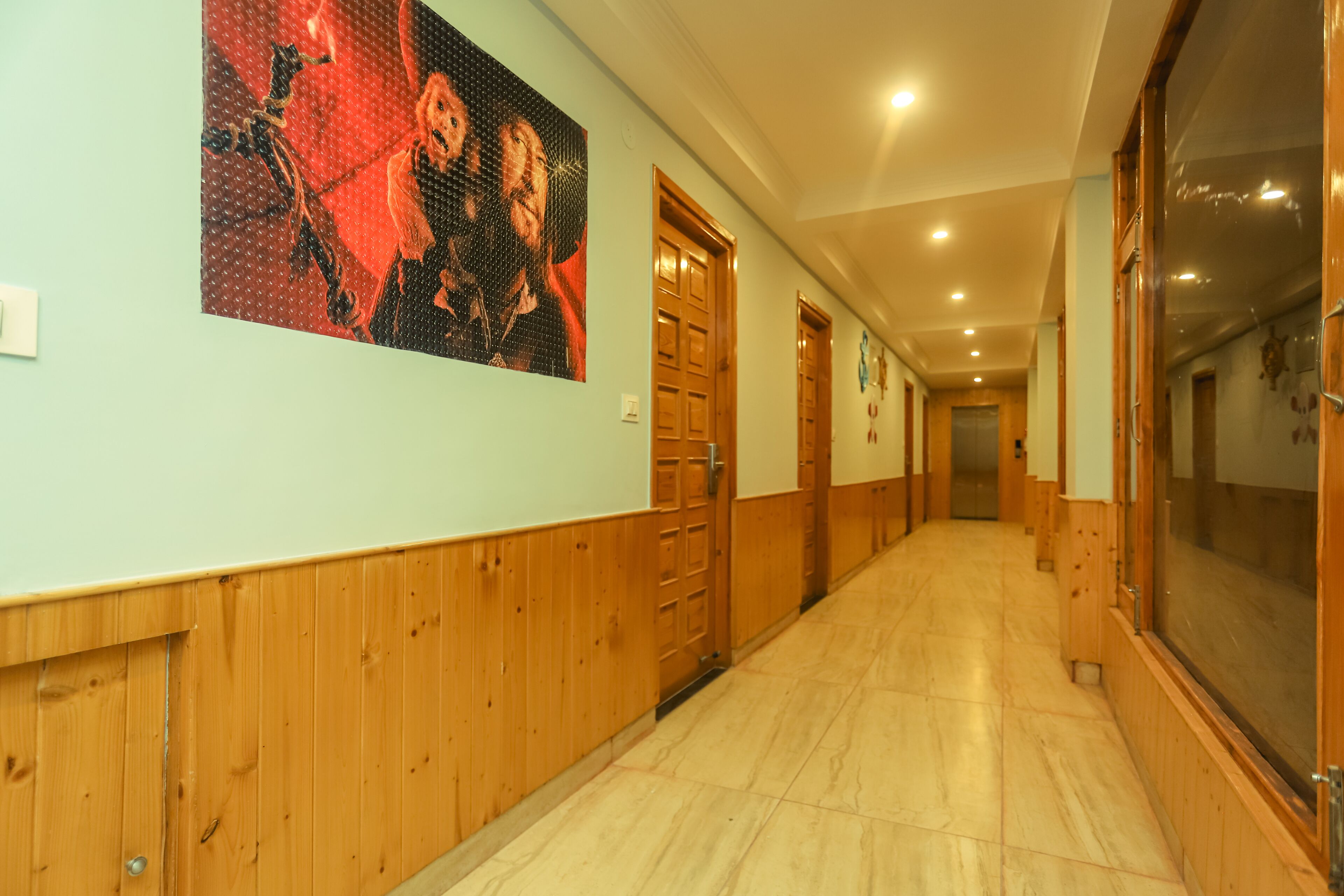 A hallway with wooden paneling, a large poster on the wall, and wooden doors.