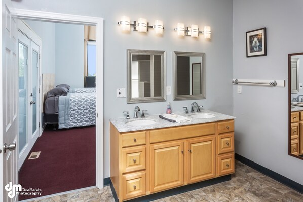 A bathroom with a double sink vanity, two large mirrors, and a towel rack. - Sleeping Lady Mountain View( The WOW Factor) Suite (Anchorage)