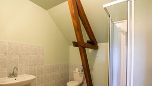 A bathroom with a sink, toilet, and shower area.
