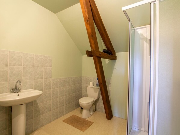 Ein Badezimmer mit Waschbecken, Toilette und Duschbereich.