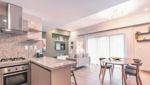Eine moderne Küche mit Granit-Arbeitsplatten, Edelstahlgeräten und einem Essbereich mit rundem Tisch und Stühlen.