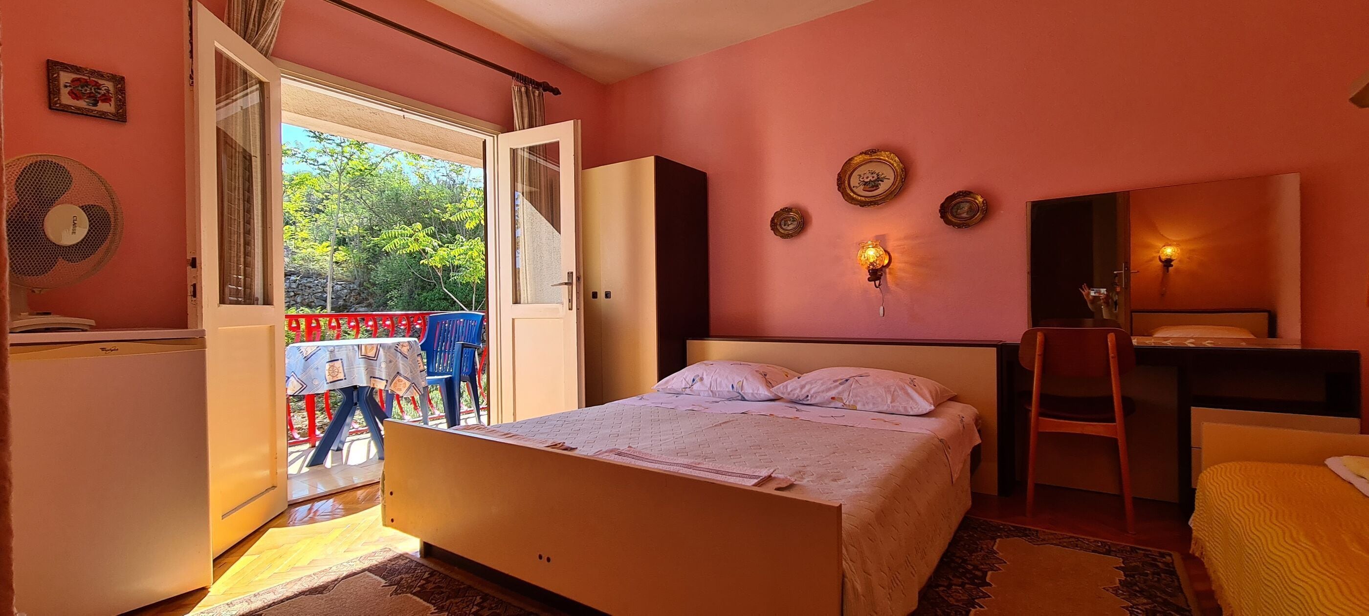Een slaapkamer met een bed, bureau, stoel en een kledingkast.