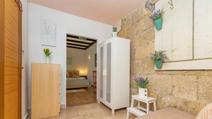 A compact room with a bed, a wardrobe, a small table, and potted plants. - Apartments Cash and Dash (Krilo Jesenice)