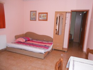 A bedroom with a bed, a wardrobe, a mirror, and two framed pictures on the wall. - Apartments Vesna (Moscenicka Draga)