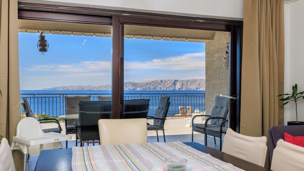 A balcony with a view of the sea, a dining table with chairs, and a sofa. - Apartment Aneta (Povile)