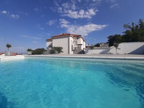 Una piscina al aire libre, una piscina climatizada, tumbonas