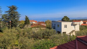 Ein Wohngebiet mit Häusern, blauem Himmel und einem Blick auf das Meer in der Ferne.