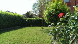 A well-maintained garden with a lawn, a rose bush, and a hedge. - Apartment Anto (Umag)